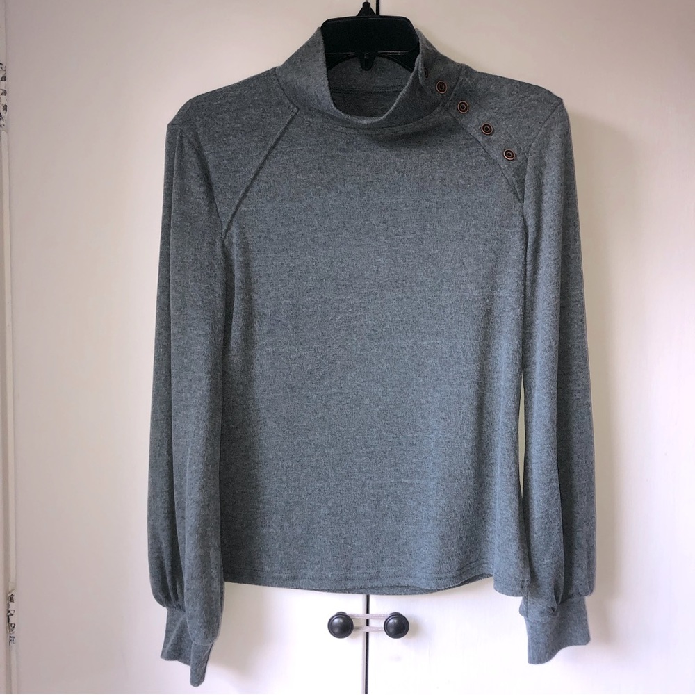 Heather gray mock turtleneck with brass accent buttons and cuffed long sleeves